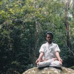 man meditating in a forest
